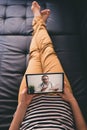 Woman lying on a sofa and talking with a doctor online using digital tablet. Telemedicine concept. Royalty Free Stock Photo