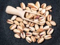 Top view of wood scoop in heap of pistachio seeds