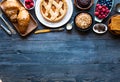 Top view of a wood table full of cakes, fruits, coffee, biscuits Royalty Free Stock Photo