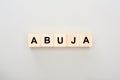 Top view of wooden blocks with Abuja lettering on grey background.