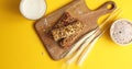 Cereal bars and oats on wooden board