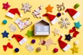 Top view of wooden calendar with Christmas decorations and Santa hats on yellow background. The twenty fifth of December. Happy