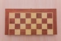Top view on wooden chess board on light wooden table background Royalty Free Stock Photo
