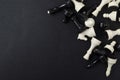 Top view of white and black chess pieces on the black background.Empy space