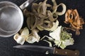 Top view of leftover vegetable peelings, knife and pot on the black kithcen table