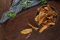 Top view of wooden cutting board on old wooden table top with tablecloth and sweet potato chips in a bowl. Royalty Free Stock Photo