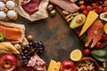 Top view of wooden cutting board with raw fish, meat, poultry, cheese, fruits, vegetables, olive oil, eggs, baguette and Royalty Free Stock Photo