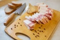 Top view of wooden cutting board with salo, peppercorn, slices of bread, garlic and knife, lunch time, traditional Ukrainian food Royalty Free Stock Photo