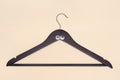 Top view of a wooden dark brown hanger with google eyes on a colored background. Clothing sale concept. Funny clothes