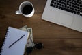 Top view of wooden desk with objects. Laptop, notebook, coffee cup, money, pen and sunglasses. Royalty Free Stock Photo