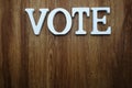 Wooden letters with word vote alphabet on wooden backgrou