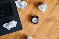 Top view of wooden office desk with clock,, notebook, crumpled paper balls Royalty Free Stock Photo