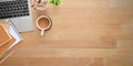 Top view wooden office desk with coffee, computer laptop, note, pencils, pencil holder and potted plant Royalty Free Stock Photo