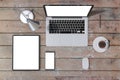 Top view of wooden office desktop with empty white laptop, smartphone and cellphone, coffee cup and supplies. Mock up, 3D Royalty Free Stock Photo