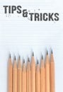 Top view of wooden pencils with word Tips and tricks on paper