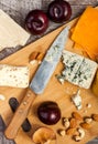 On top view of wooden plate with different tupe of cheese