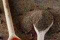 Top view of a wooden spoon full of black pepper on wooden barrel background, selective focus. Royalty Free Stock Photo