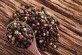 Top view of a wooden spoon full of allspice seeds on wooden background, shallow depth of field, front focus