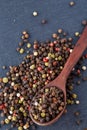 Top view of a wooden spoon full of allspice seeds on dark background, shallow depth of field, front focus