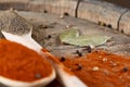 Top view of a wooden spoons full of paprica and black pepper on wooden barrel background, selective focus. Royalty Free Stock Photo