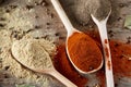 Top view of a wooden spoons full of paprica and black pepper on wooden barrel background, selective focus. Royalty Free Stock Photo