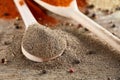 Top view of a wooden spoons full of paprica and black pepper on wooden barrel background, selective focus. Royalty Free Stock Photo