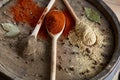 Top view of a wooden spoons full of paprica and black pepper on wooden barrel background, selective focus. Royalty Free Stock Photo