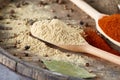 Top view of a wooden spoons full of paprica and curry on wooden barrel background, selective focus. Royalty Free Stock Photo