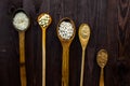 Top view of wooden spoons on which lie an assortment of different cereals on a wooden table Royalty Free Stock Photo
