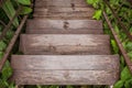 Wooden stairs or walkway go down to outdoor garden surrounded with green trees. Royalty Free Stock Photo