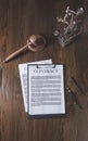 top view of wooden table with document, hammer and statue of lady justice,