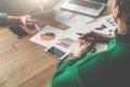 Top view.On wooden table are paper charts,smartphones and laptop.Two business women sitting at table and talking. Royalty Free Stock Photo