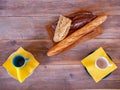 Top view on the wooden table with two cups on yellow napkins and a board of three different buns Royalty Free Stock Photo