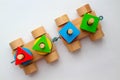 Top view wooden train on the white background. The colorful details of plaything draw the attention of the baby.