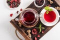 Top view of a wooden tray with a glass teapot and a white cup of hibiscus tea. a useful vitamin drink rich in vitamins Royalty Free Stock Photo