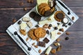 Top view on a wooden white tray with different types of chocolate, cookies and nuts on a wooden brown background Royalty Free Stock Photo