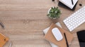 Top view wooden workspace office desk with computer and office supplies. Flat lay work table with blank notebook, keyboard, green Royalty Free Stock Photo