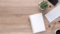 Top view wooden workspace office desk with computer and office supplies. Flat lay work table with blank notebook, keyboard, green Royalty Free Stock Photo