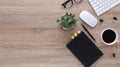 Top view wooden workspace office desk with computer and office supplies. Flat lay work table with blank notebook, keyboard, green Royalty Free Stock Photo