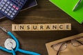 Top view word INSURANCE with stethoscope on table