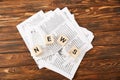 top view of word news made of alphabet cubes on heap of newspapers on wooden background Royalty Free Stock Photo