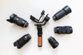 Top view of work space videographer with digital gear, gimbal stabilizer, lens and camera accessory on white table background