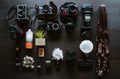 Top view of work space wedding photographer. Set of digital and analog cameras on dark background