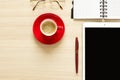 Top view on work table. Coffee cup, tablet, glasses, notes and pen Royalty Free Stock Photo
