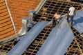 Top view of a worker placing metal sheets on a house to renovate the roof of a commercial point
