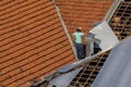 Top view of a worker placing metal sheets on a house to renovate the roof of a commercial point