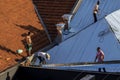 Top view of a worker placing metal sheets on a house to renovate the roof of a commercial point