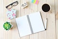 Top view of working desk with blank notebook with pen, coffee cup, colorful note pad, cube calendar and eyeglasses on wooden backg Royalty Free Stock Photo