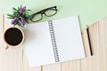 Top view of working desk with blank notebook with pencil, coffee cup, eyeglasses and plant on wooden background Royalty Free Stock Photo