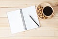 Top view of working desk with blank notebook with pencil, cookies and coffee cup on wooden background Royalty Free Stock Photo